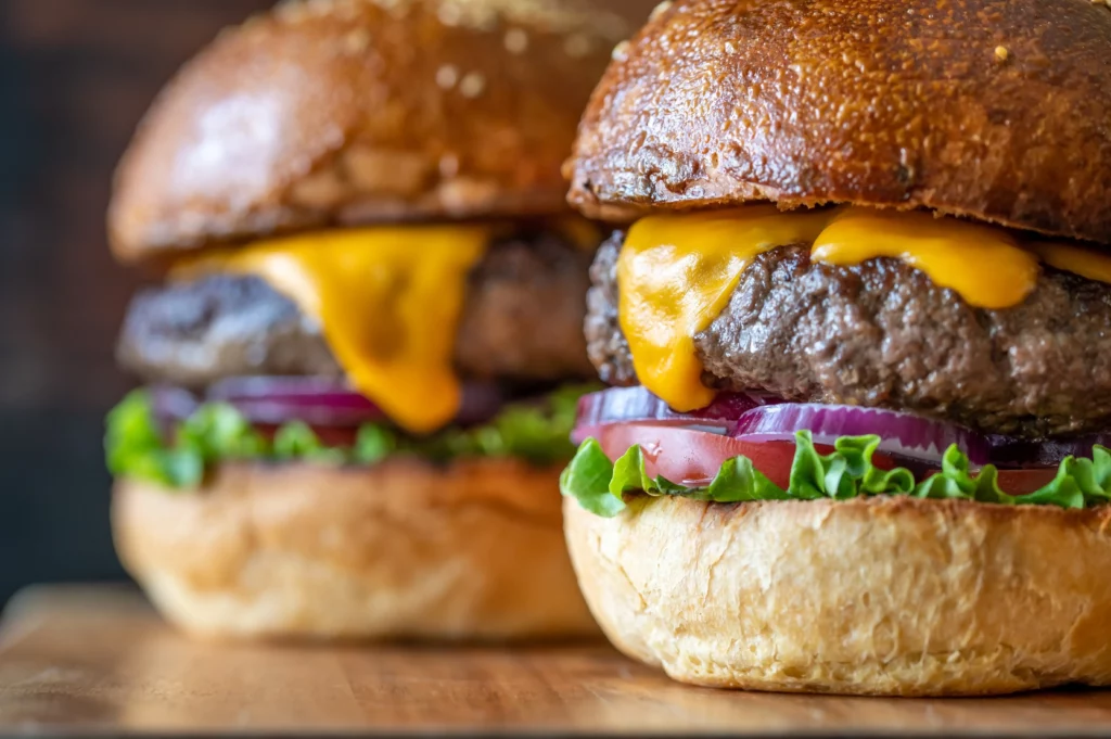 Zwei Burger auf dem Holzbrett aus nächster Nähe von food fotograf hannover.
