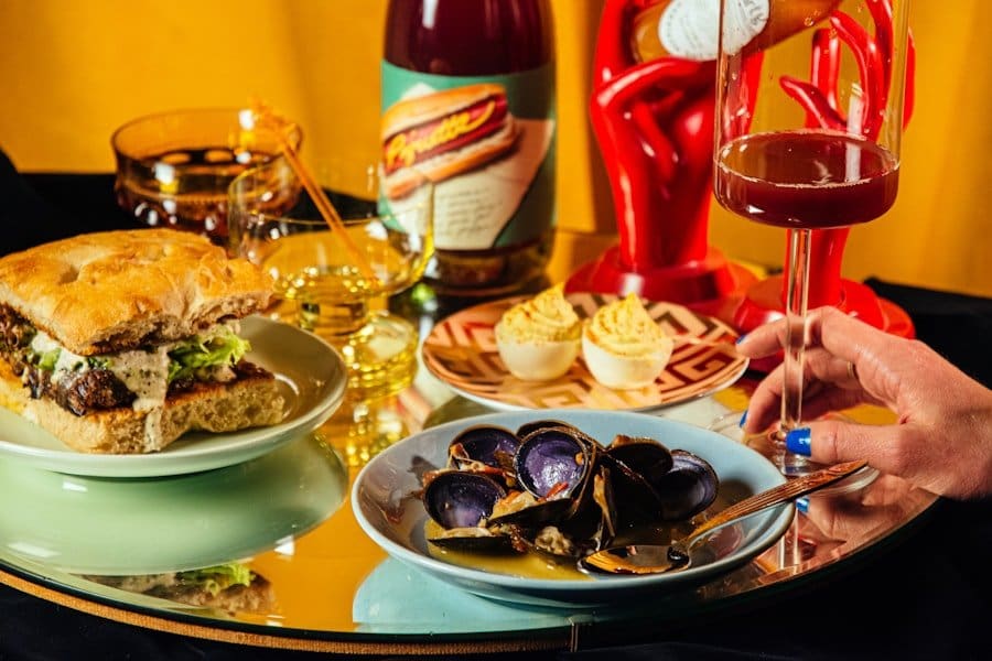 Der Food Fotograf - Ein gedeckter Tisch mit einem Sandwich auf einem grünen Teller, einer Schüssel Muscheln und zwei gefüllten Eiern.