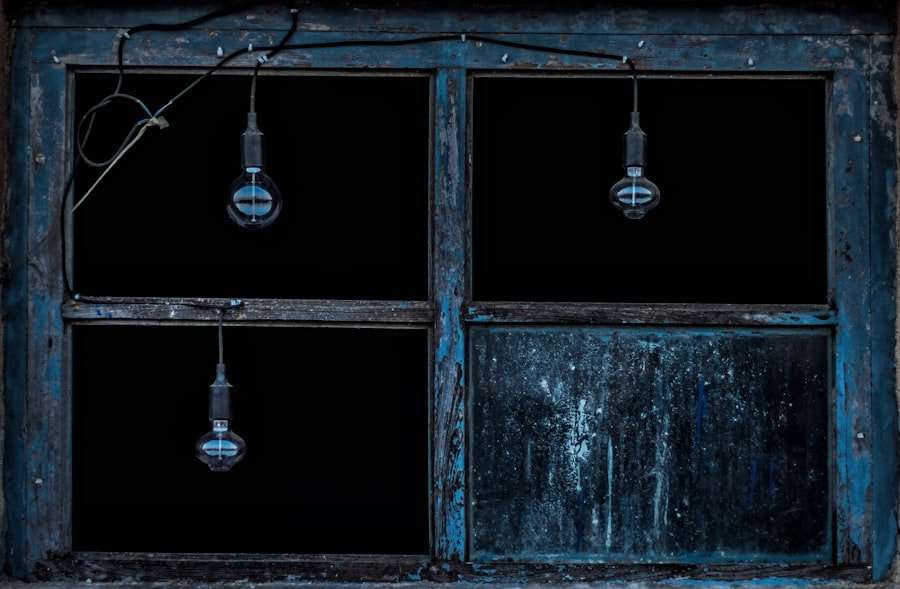 Der Food Fotograf - Gezeigt wird ein altes, verwittertes Fenster mit blau gestrichenen Holzrahmen bei Nacht.