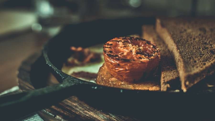 Der Food Fotograf - Eine gegrillte halbe Tomate liegt zusammen mit zwei weiteren Brotscheiben auf einer Brotscheibe in einer Pfanne.
