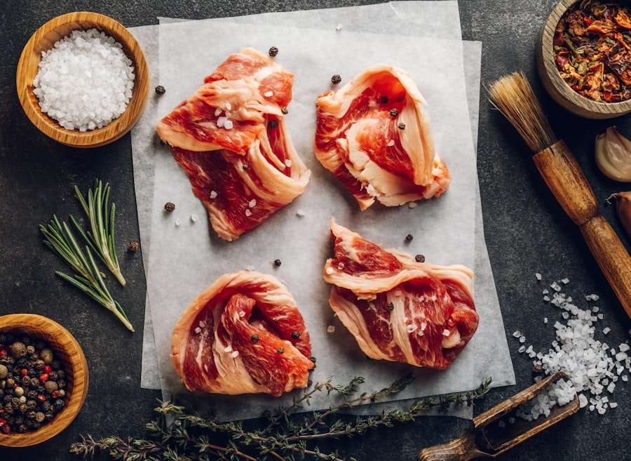 Vier Scheiben rohes Rindfleisch auf einem Blatt Backpapier liegen auf einer dunklen Oberfläche, perfekt für Food-Fotografie.