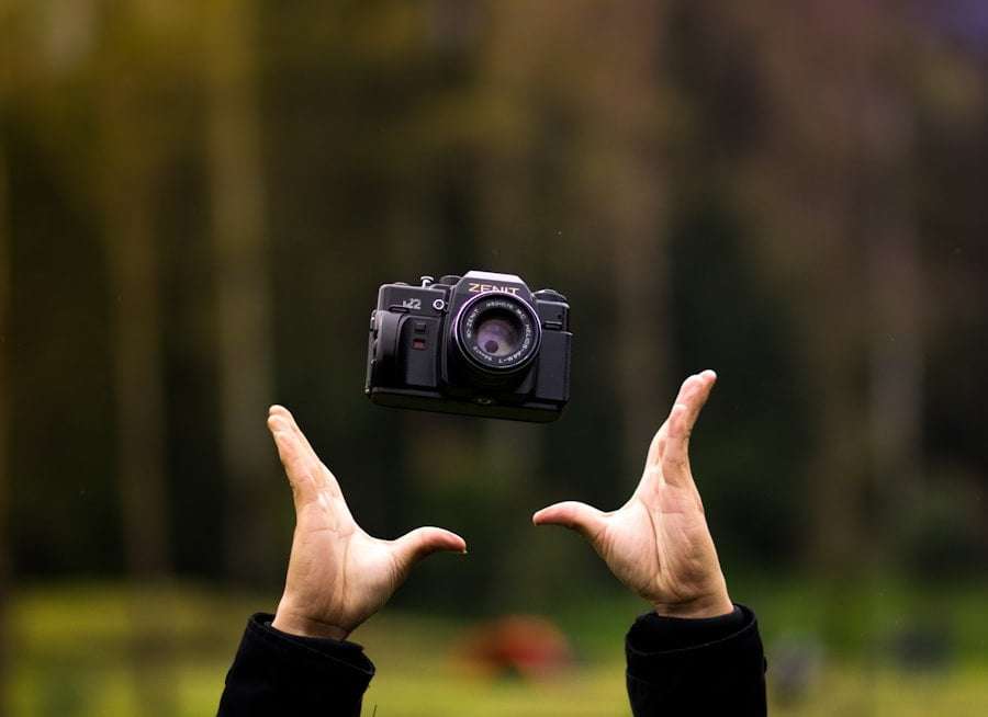 Der Food Fotograf - Eine alte Kamera ist vor einem verschwommenen Außenhintergrund in der Luft schwebend zu sehen.