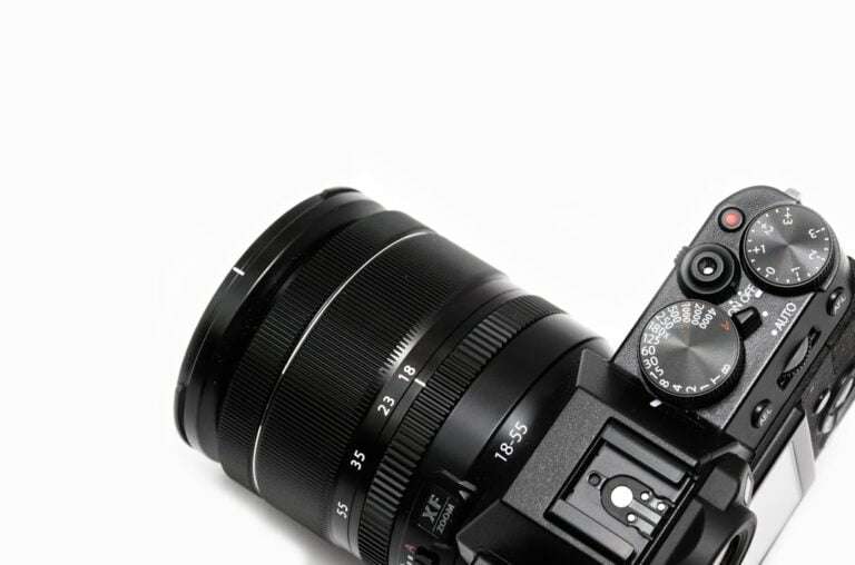 Der Food Fotograf - Eine Nahaufnahme einer schwarzen Digitalkamera, auf der das Objektiv und die Einstellräder zu sehen sind.